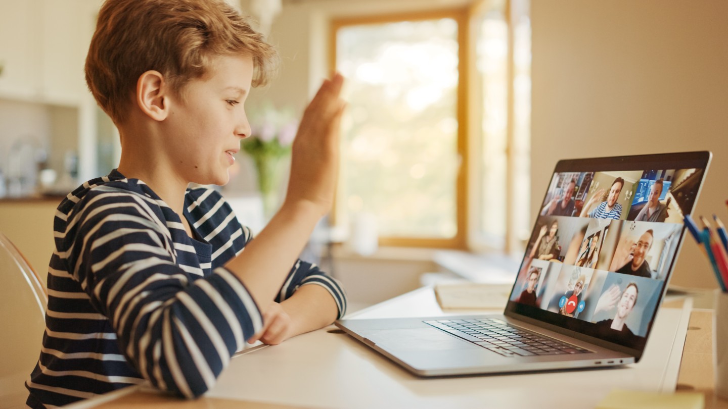 Kind vor Laptop bei einer Videokonferenz