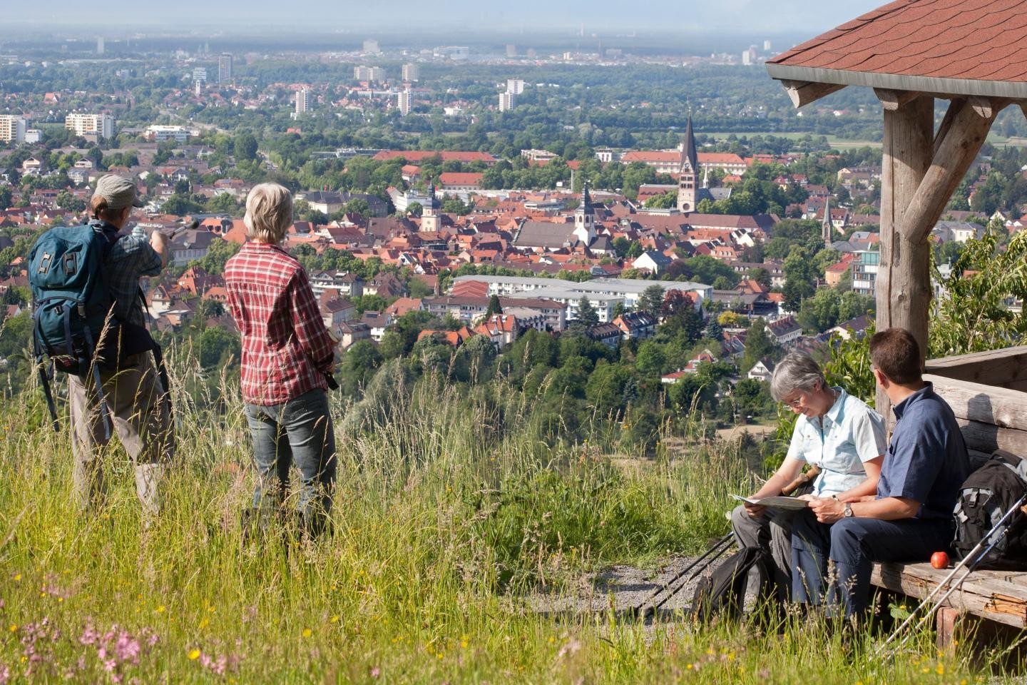 Eine Wandergruppe steht am Hannessen-Pavillon und genießt die Aussicht über Ettlingen