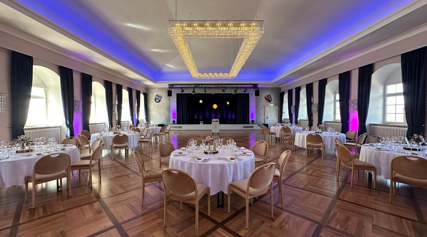 Epernaysaal bestuhlt mit runden Tischen, weißen Tischdecken und jeweils 8 Stühlen für Bankett