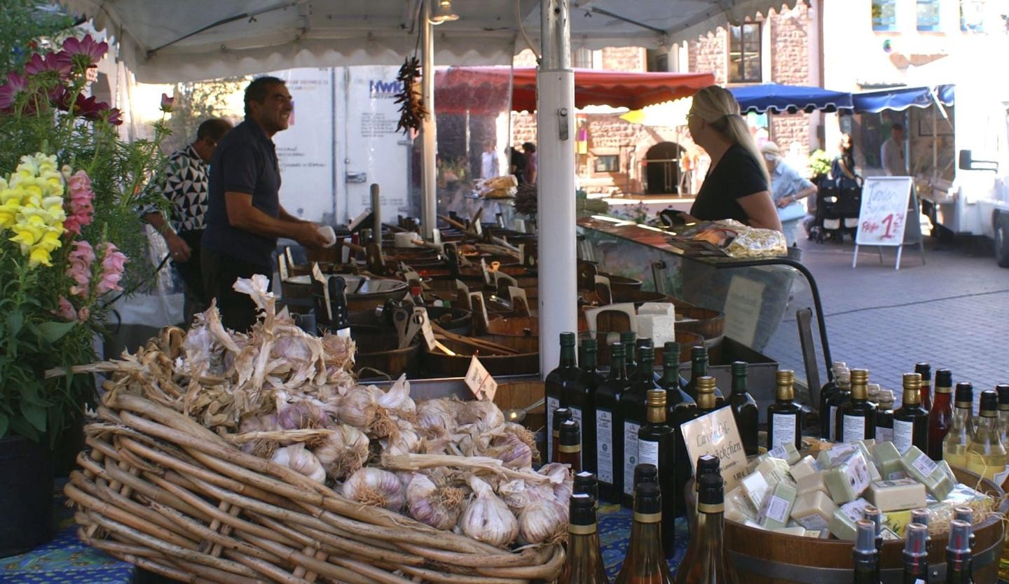 Das Bild zeigt eine Einkaufssituation auf dem Ettlinger Wochenmarkt. 